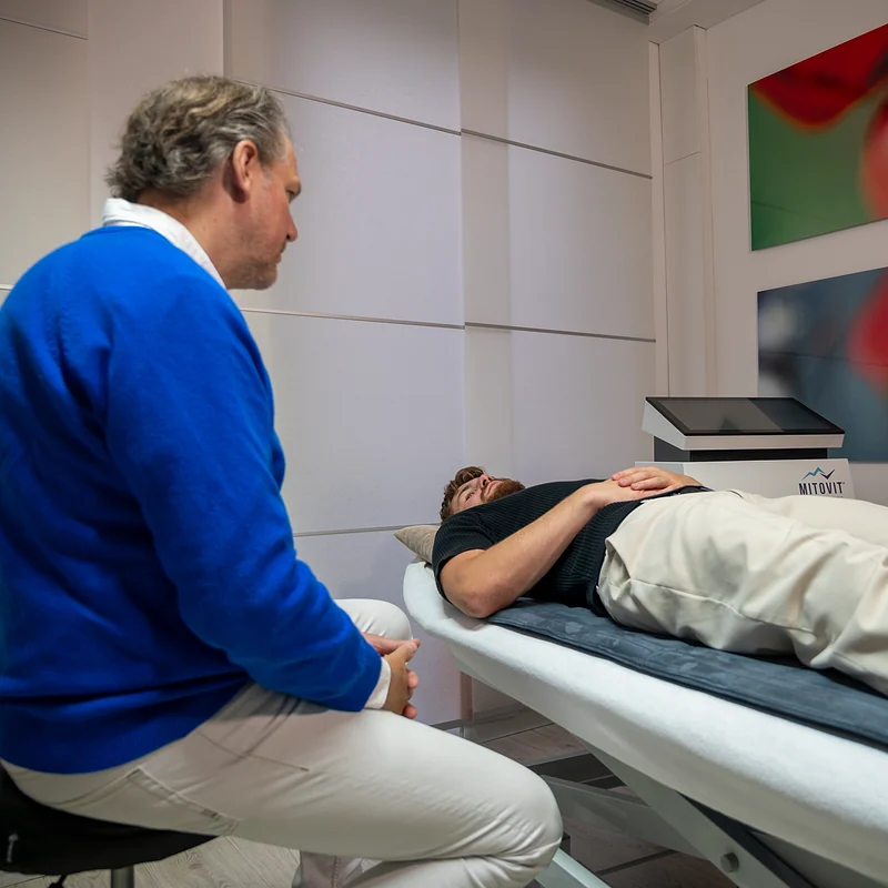 Dr. Meschede begleitet ein IHHT-Training auf der Liege in der Praxis